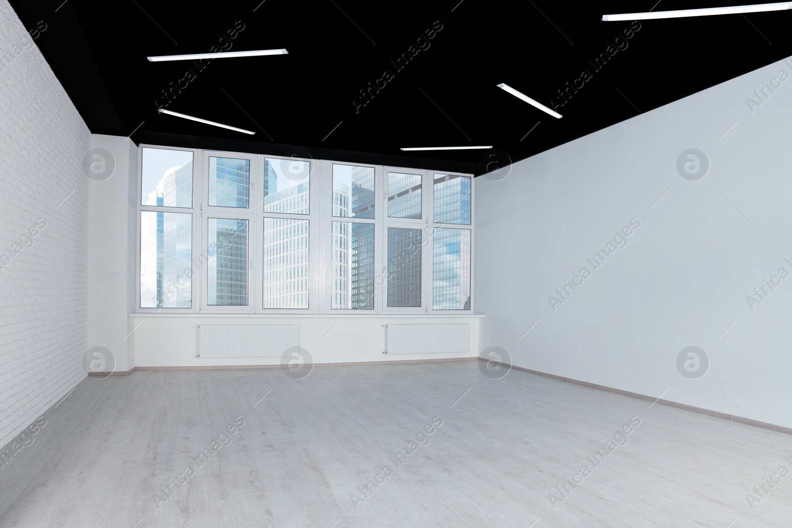 Photo of Empty office room with black ceiling and clean windows. Interior design