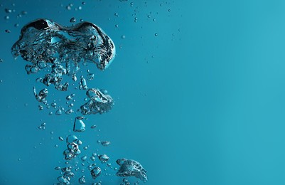 Air bubbles in water on blue background. Space for text