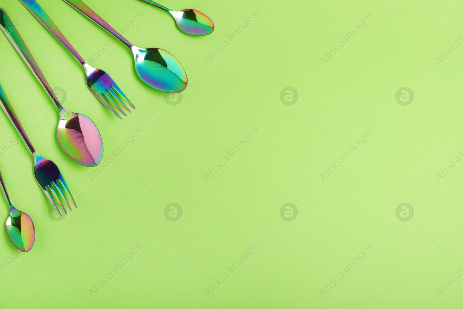 Photo of Flat lay composition with cutlery on light green background, space for text