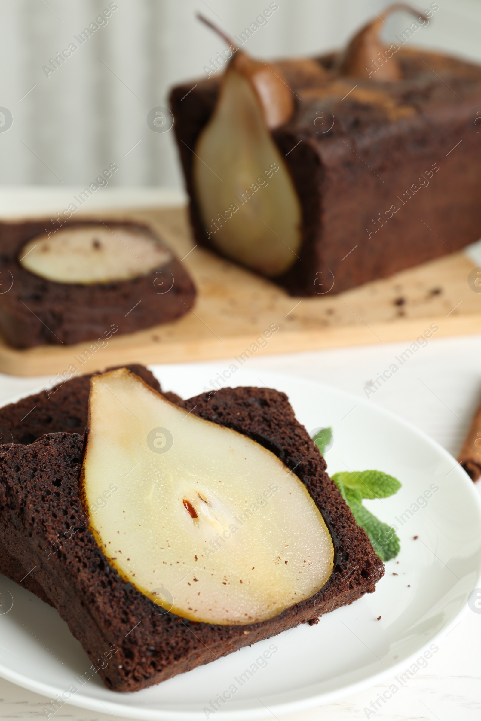 Photo of Tasty pear bread served with mint on white wooden table. Homemade cake