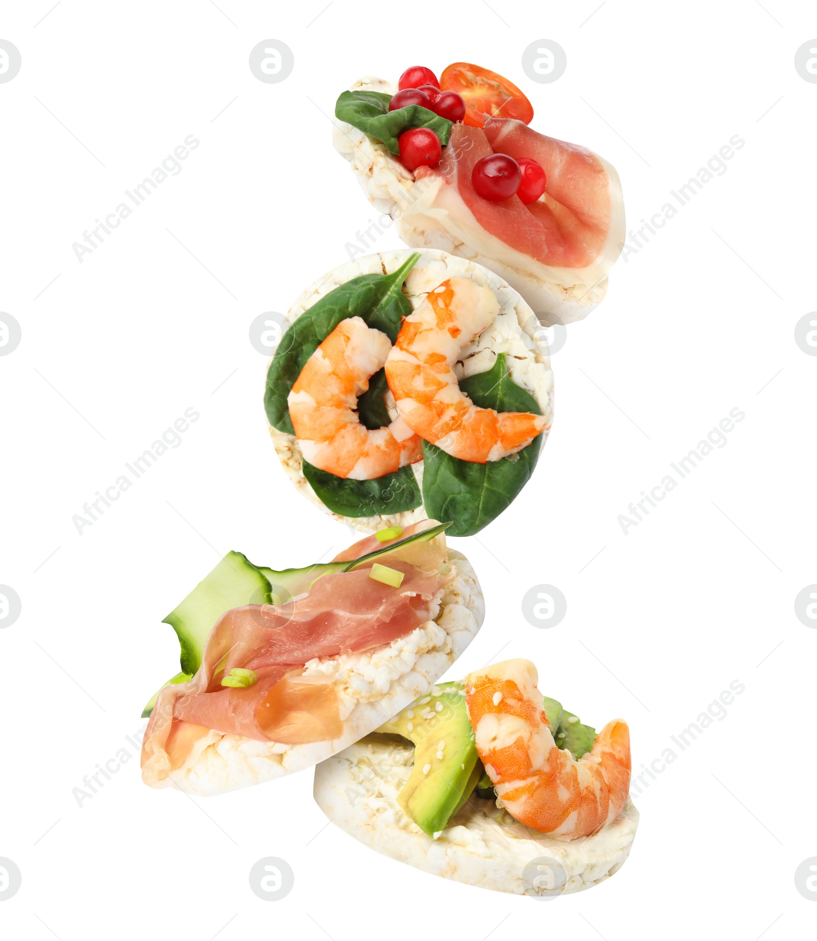 Image of Puffed corn cakes with different toppings falling on white background