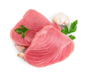 Photo of Raw tuna fillets, parsley and garlic on white background, top view