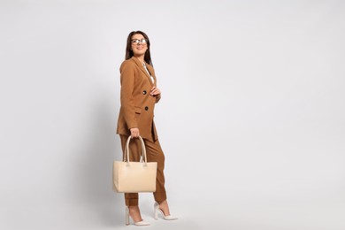 Young woman with stylish bag on white background