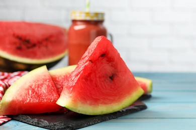 Cut juicy watermelon on light blue wooden table, space for text