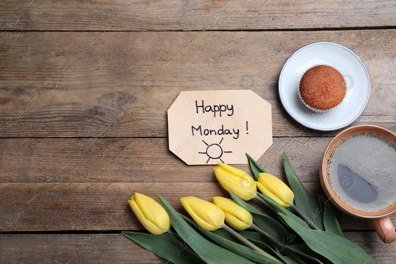 Photo of Happy Monday message, aromatic coffee, cupcake and tulips on wooden table, flat lay