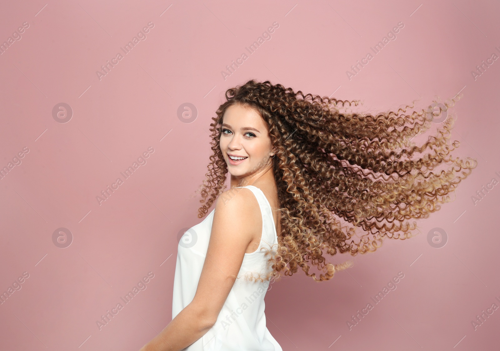 Photo of Portrait of beautiful young woman with shiny wavy hair on color background