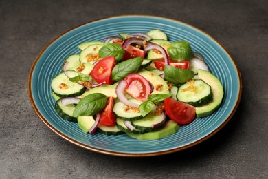 Photo of Blue plate with tasty salad on grey table
