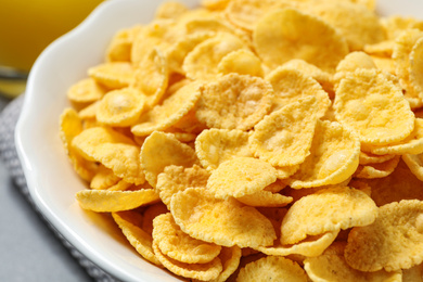 Photo of Tasty crispy corn flakes in bowl, closeup