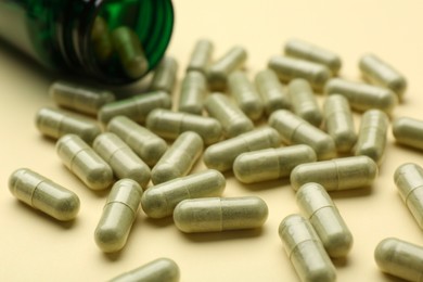 Many vitamin pills on beige background, closeup