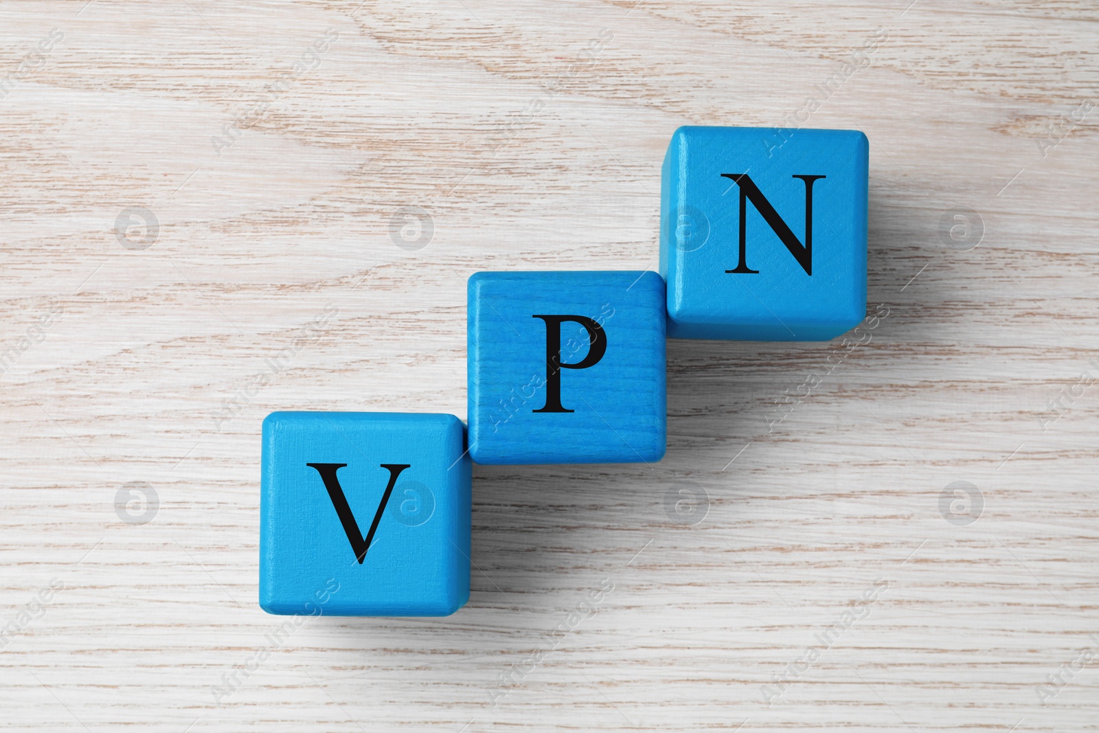 Photo of Light blue cubes with acronym VPN on wooden table, top view