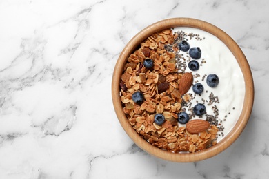 Photo of Tasty homemade granola served on white marble table, top view with space for text. Healthy breakfast