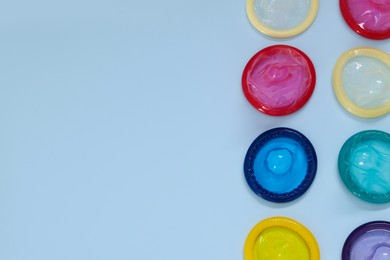 Photo of Condoms on light blue background, flat lay with space for text. Safe sex