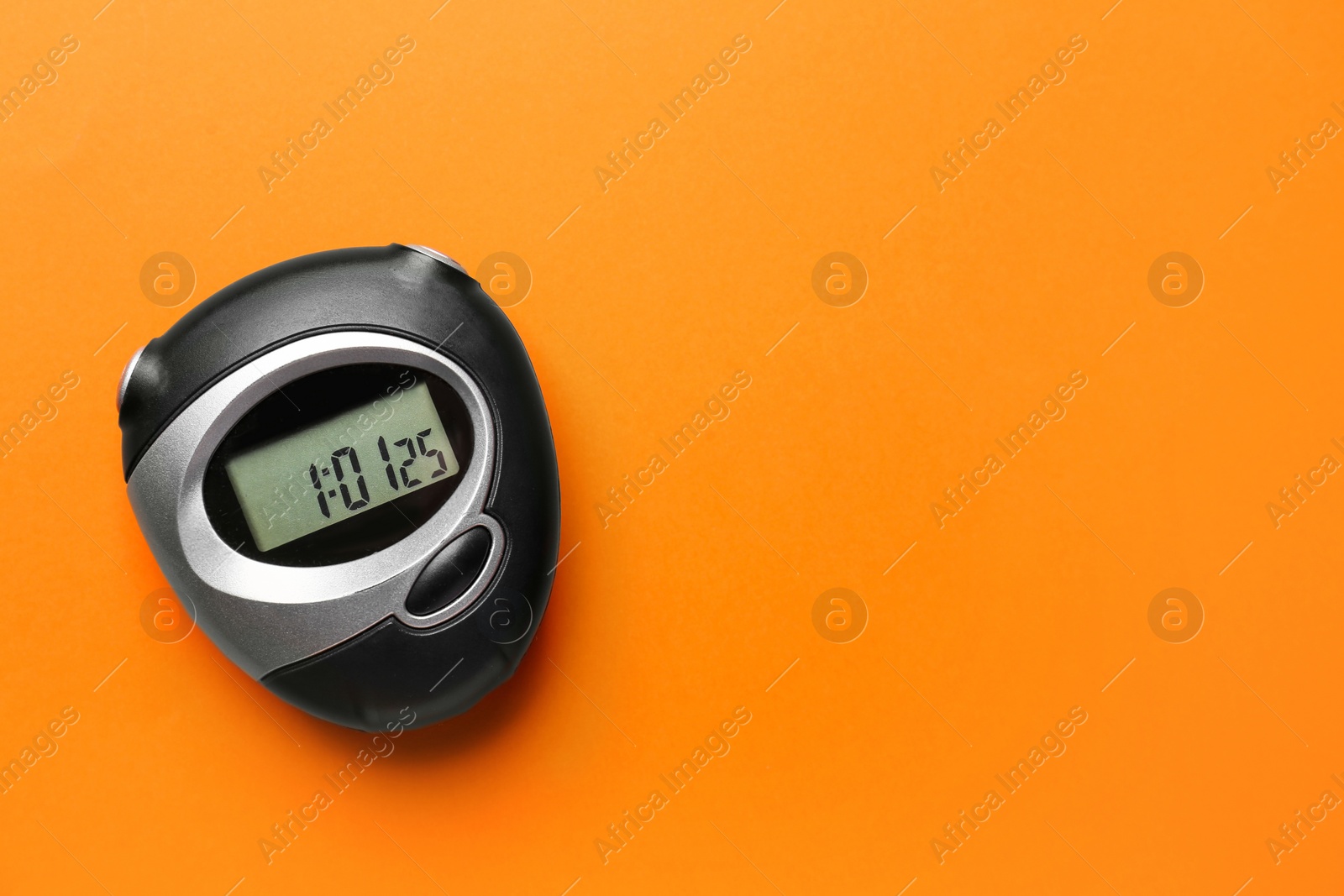 Photo of Digital timer on orange background, top view. Space for text
