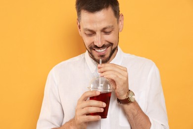 Photo of Man drinking delicious juice on orange background