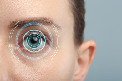 Vision test. Woman and digital scheme focused on her eye against grey background, closeup