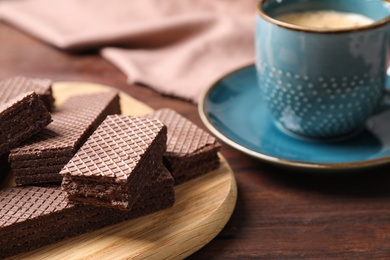 Delicious chocolate wafers on wooden table, closeup. Space for text