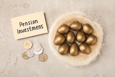 Photo of Golden eggs in nest, coins and card with phrase Pension Investments on light table, flat lay