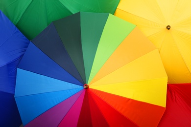 Photo of Many stylish colorful umbrellas as background, closeup