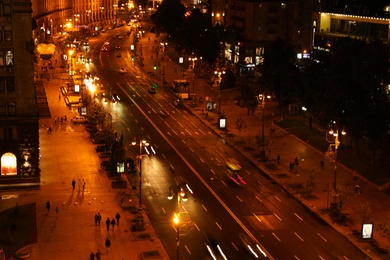 Photo of KYIV, UKRAINE - MAY 22, 2019: Beautiful view of illuminated Khreshchatyk street with buildings and road traffic