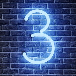 Image of Glowing neon number 3 sign on brick wall