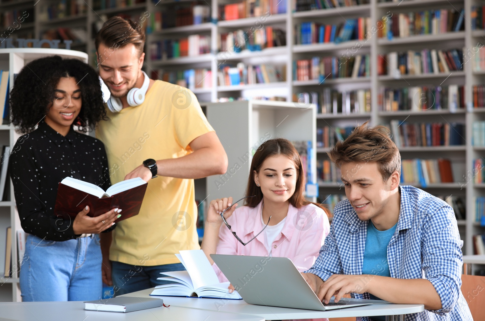 Photo of Group of young people studying at table in library