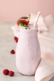 Photo of Delicious fig smoothie in bottle on light table