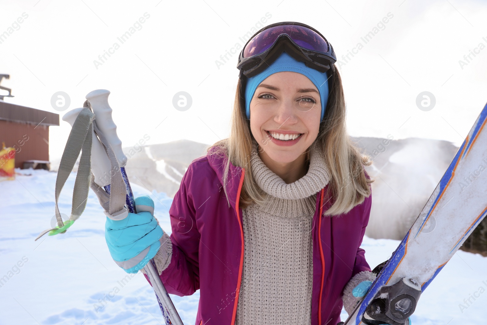 Photo of Happy young woman with ski equipment spending winter vacation in mountains