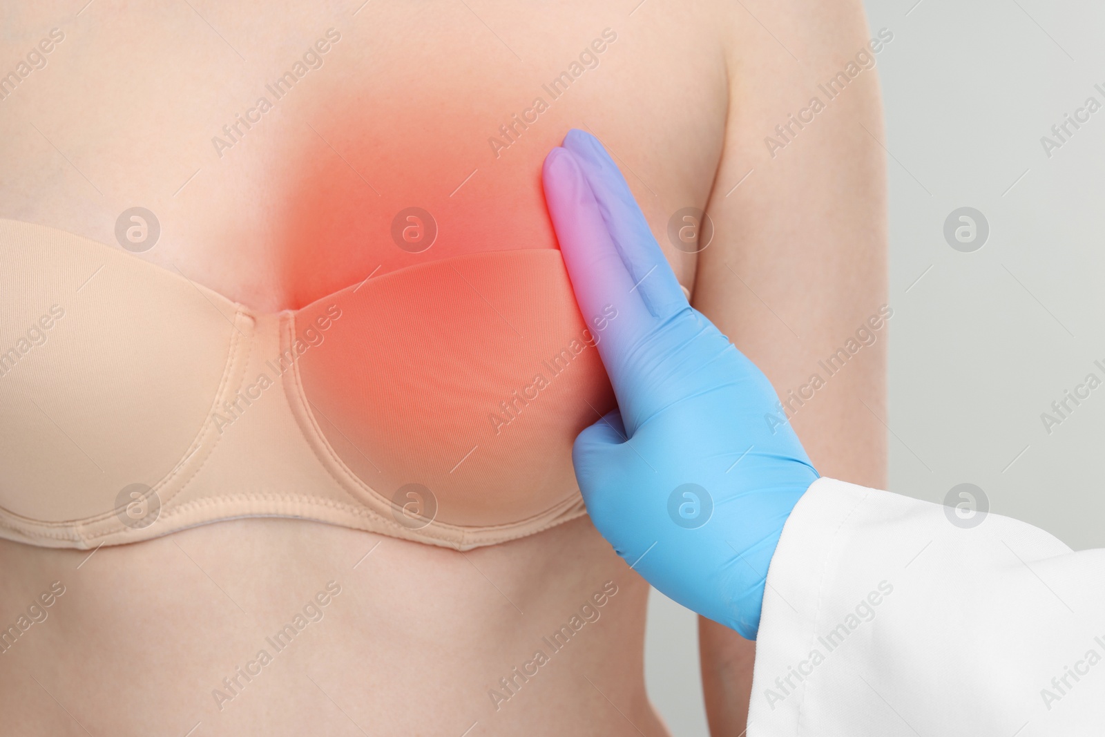 Image of Woman suffering from pain visiting breast specialist on light grey background, closeup