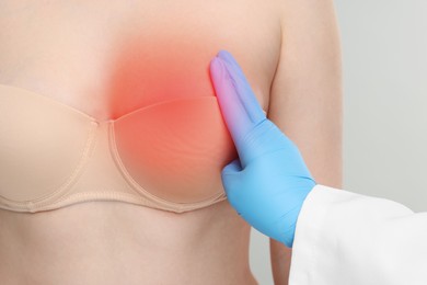 Image of Woman suffering from pain visiting breast specialist on light grey background, closeup