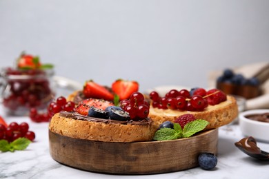 Photo of Tasty organic rusks with different toppings and ingredients on white marble table, closeup