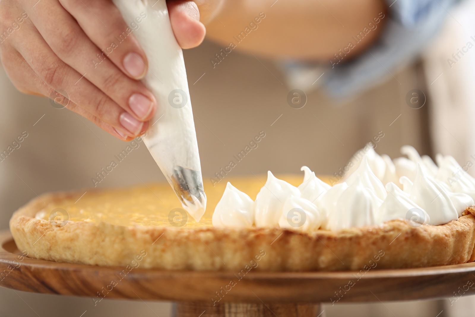 Photo of Woman preparing lemon meringue pie, closeup view
