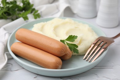 Photo of Delicious boiled sausages, mashed potato, parsley and fork on table, closeup