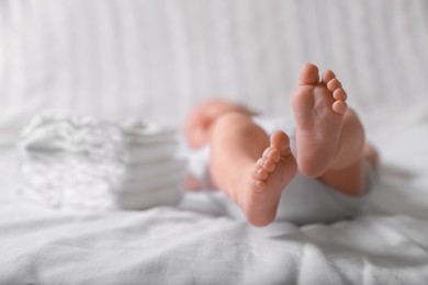 Photo of Little baby lying at bed, focus on legs