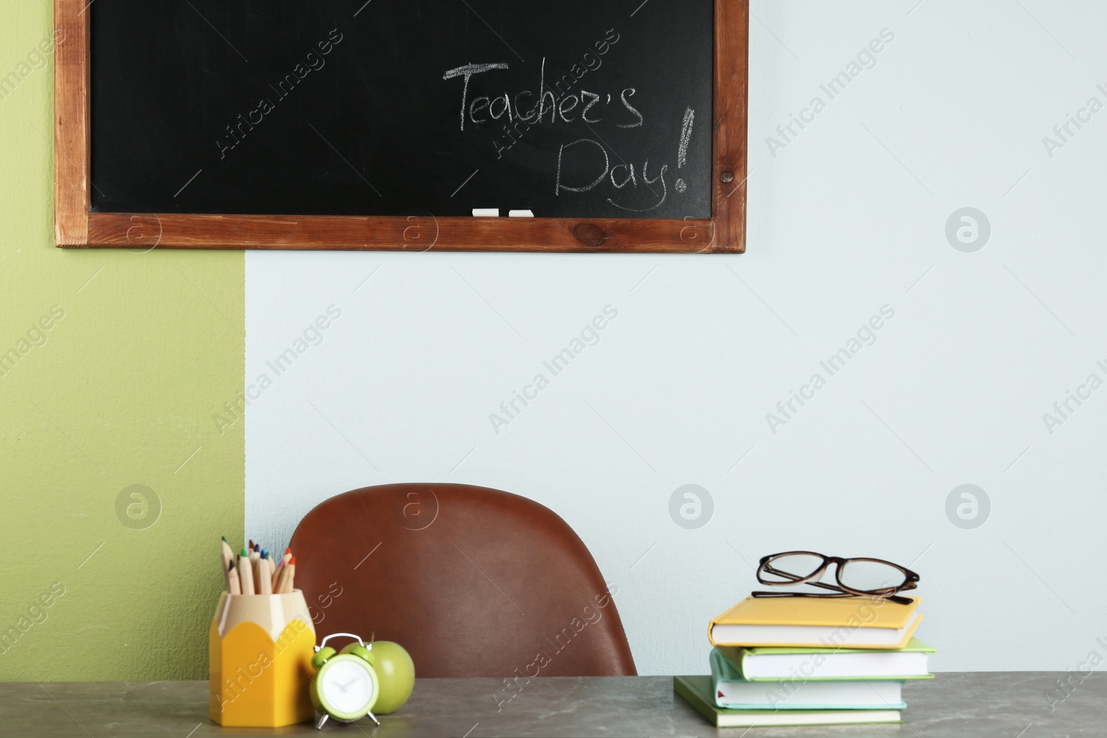 Photo of Table with books and stationery in classroom. Teacher's day