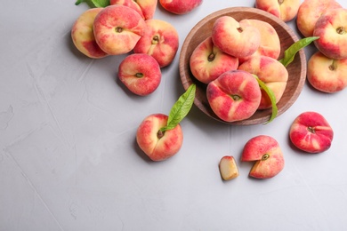 Photo of Fresh ripe donut peaches on light table, flat lay. Space for text