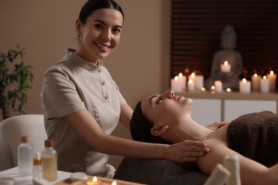 Spa therapy. Beautiful young woman lying on table during massage in salon