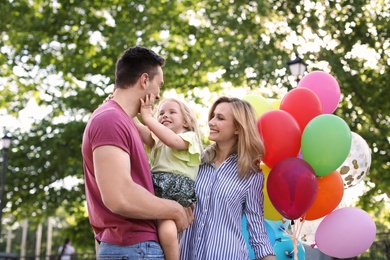 Photo of Happy family with colorful balloons outdoors on sunny day