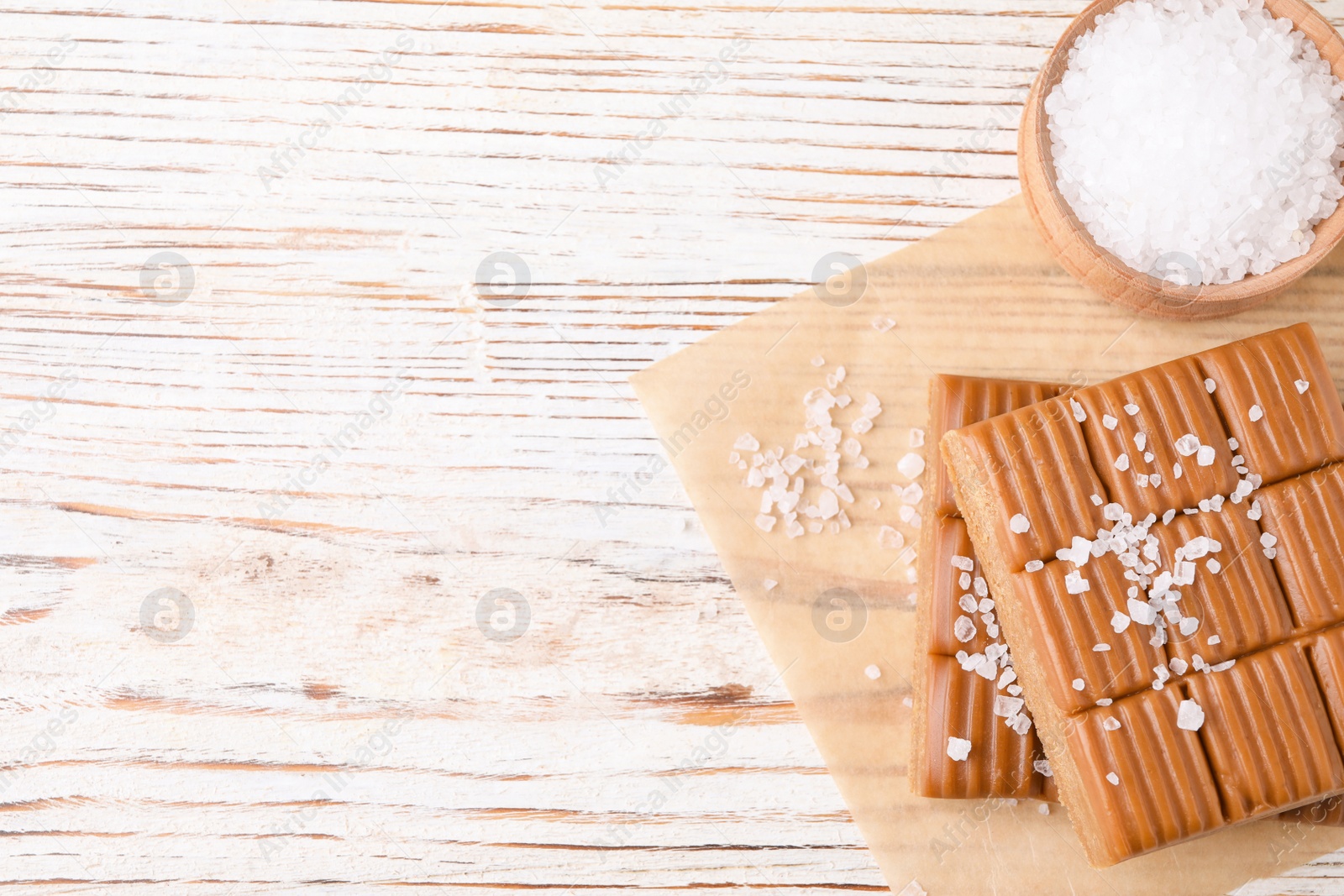 Photo of Salted caramel on white wooden table, top view. Space for text