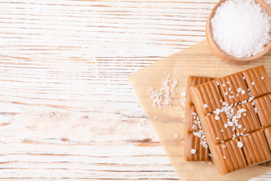 Salted caramel on white wooden table, top view. Space for text