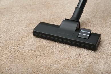 Removing dirt from carpet with modern vacuum cleaner indoors, closeup
