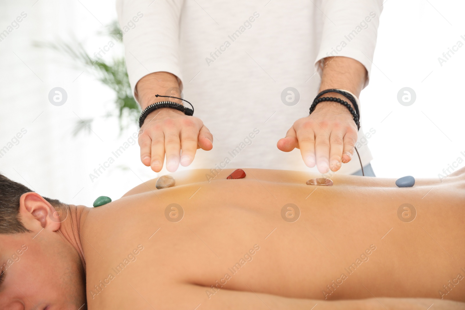 Photo of Man during crystal healing session in therapy room, closeup