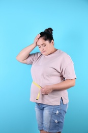 Fat woman with measuring tape on color background. Weight loss