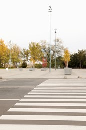 Photo of White pedestrian crossing on empty city street