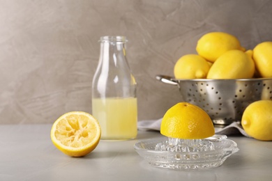 Photo of Composition with glass squeezer and lemons on table