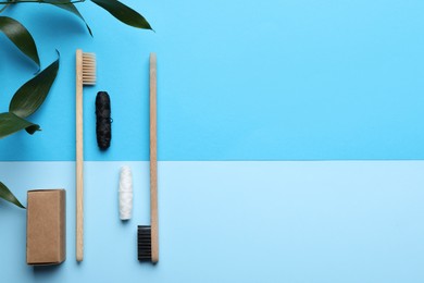 Photo of Bamboo toothbrushes, dental floss and leaves on color background, flat lay. Space for text