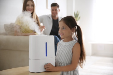 Family in room with modern air humidifier