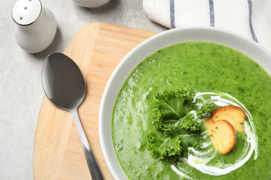 Photo of Tasty kale soup served on light grey table, flat lay