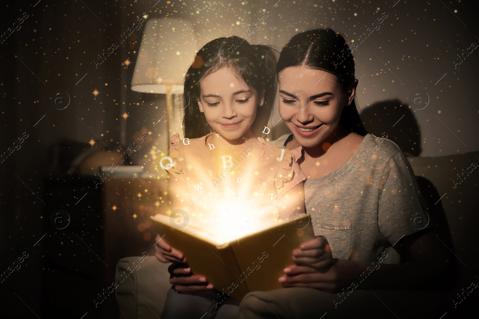 Image of Shiny magic book with letters flying over it. Girl with her mother reading fairy tale at home