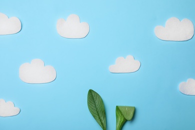 Photo of Creative flat lay composition with Easter bunny ears of green leaves and clouds on color background