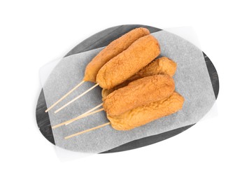 Photo of Delicious deep fried corn dogs with marble board isolated on white, top view